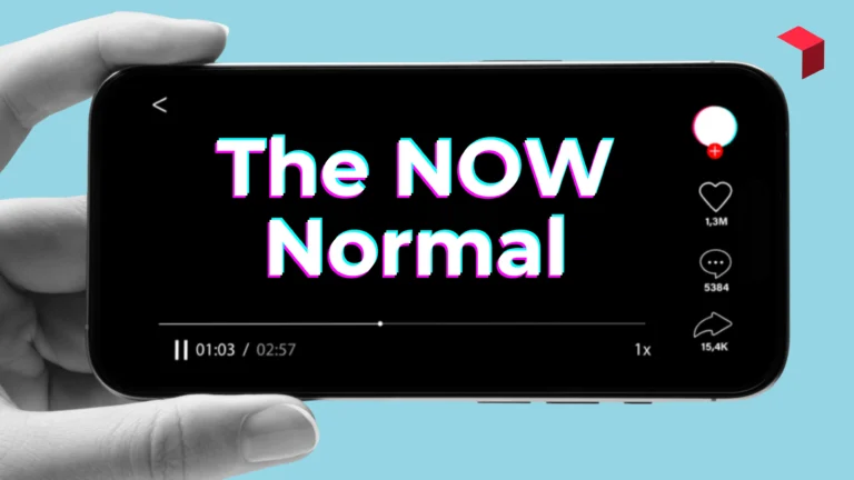 a black and white hand holding a phone that says The Now Normal